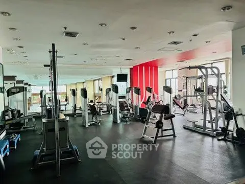 Spacious modern gym with state-of-the-art equipment and natural lighting.
