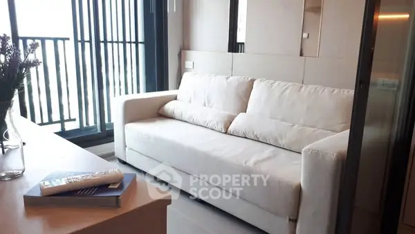 Modern living room with cozy white sofa and balcony view