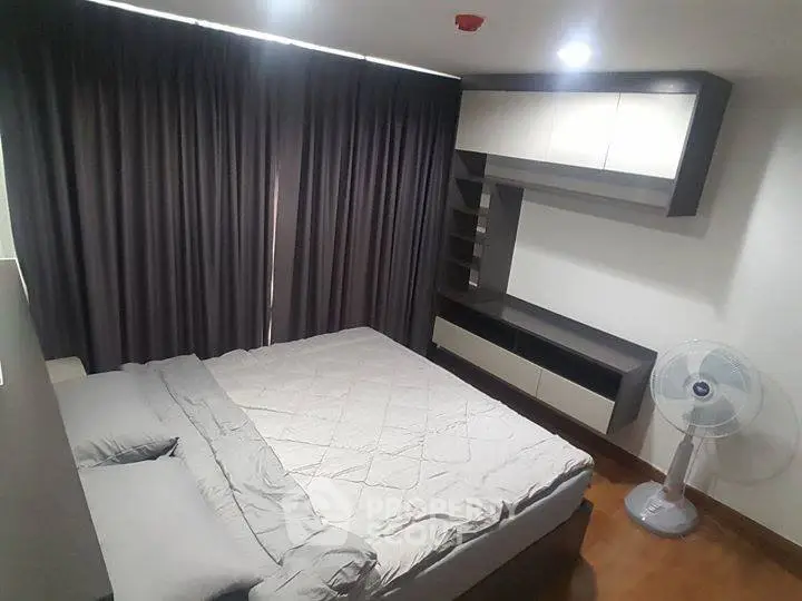 Modern bedroom with sleek furniture and cozy ambiance, featuring a comfortable bed and stylish storage solutions.