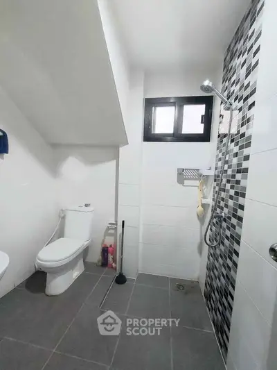 Modern bathroom with sleek shower and tiled walls in contemporary home.
