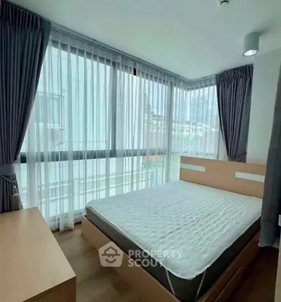 Modern bedroom with large windows and stylish curtains in a city apartment