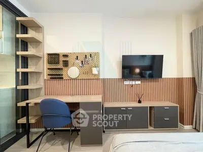 Modern bedroom with stylish desk, wall-mounted TV, and elegant decor