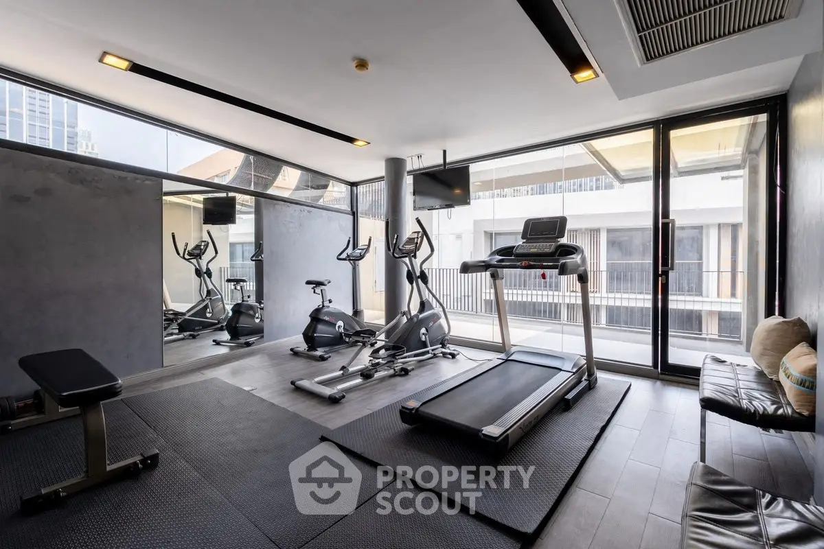 Modern gym with state-of-the-art equipment and city view, perfect for fitness enthusiasts.