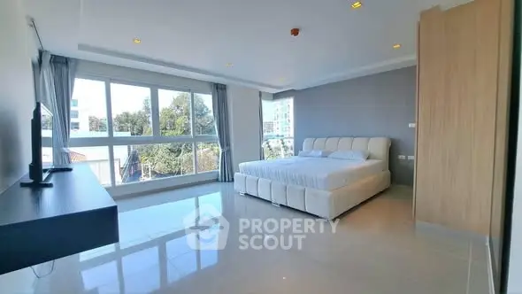 Spacious modern bedroom with large windows and natural light