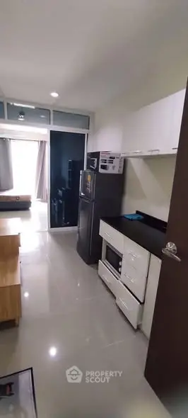 Modern kitchen with sleek appliances and open layout in stylish apartment.