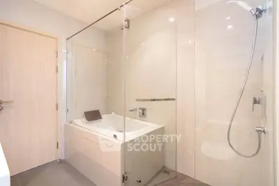 Modern bathroom with glass shower and bathtub in luxury apartment