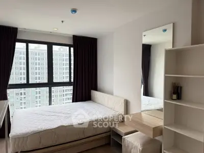 Modern bedroom with large window and city view in high-rise apartment