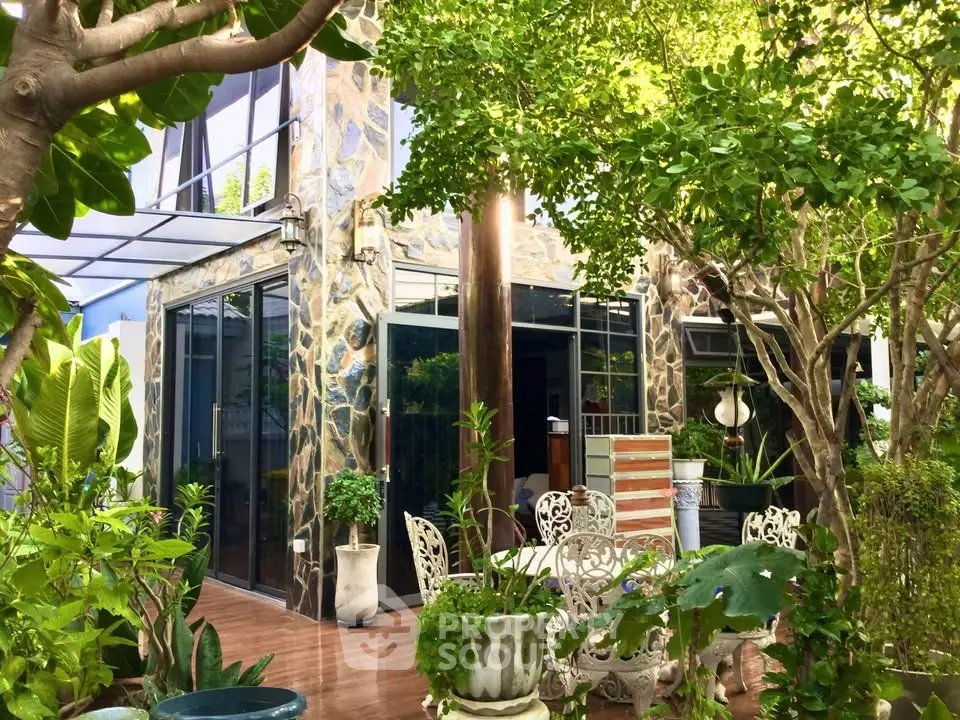 Charming garden view of a modern home with lush greenery and elegant outdoor seating.