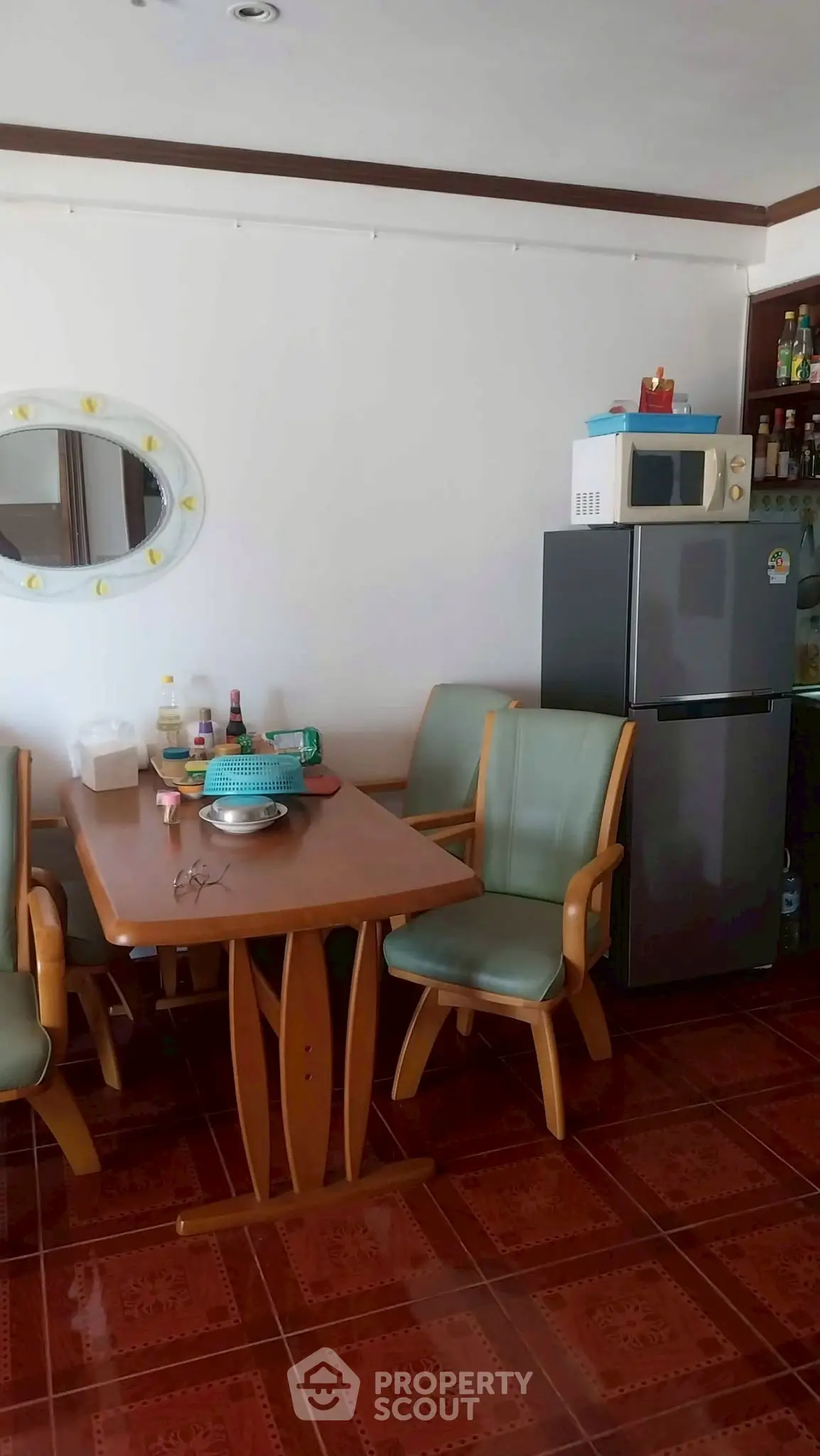Cozy dining area with wooden table, chairs, and modern appliances in a well-lit kitchen space.