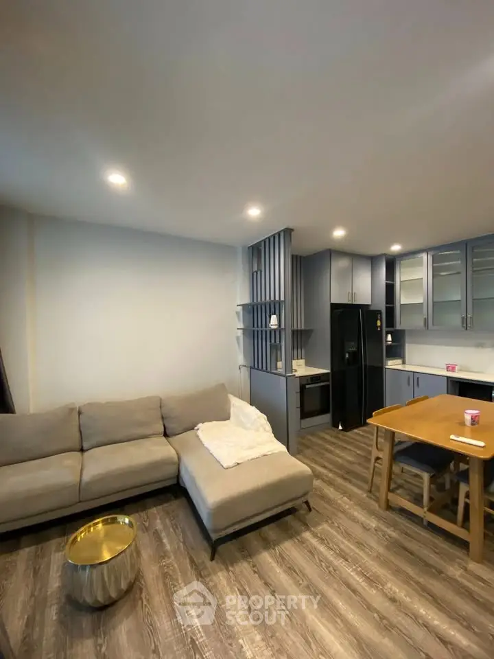 Modern living room with open kitchen, cozy sofa, and stylish decor