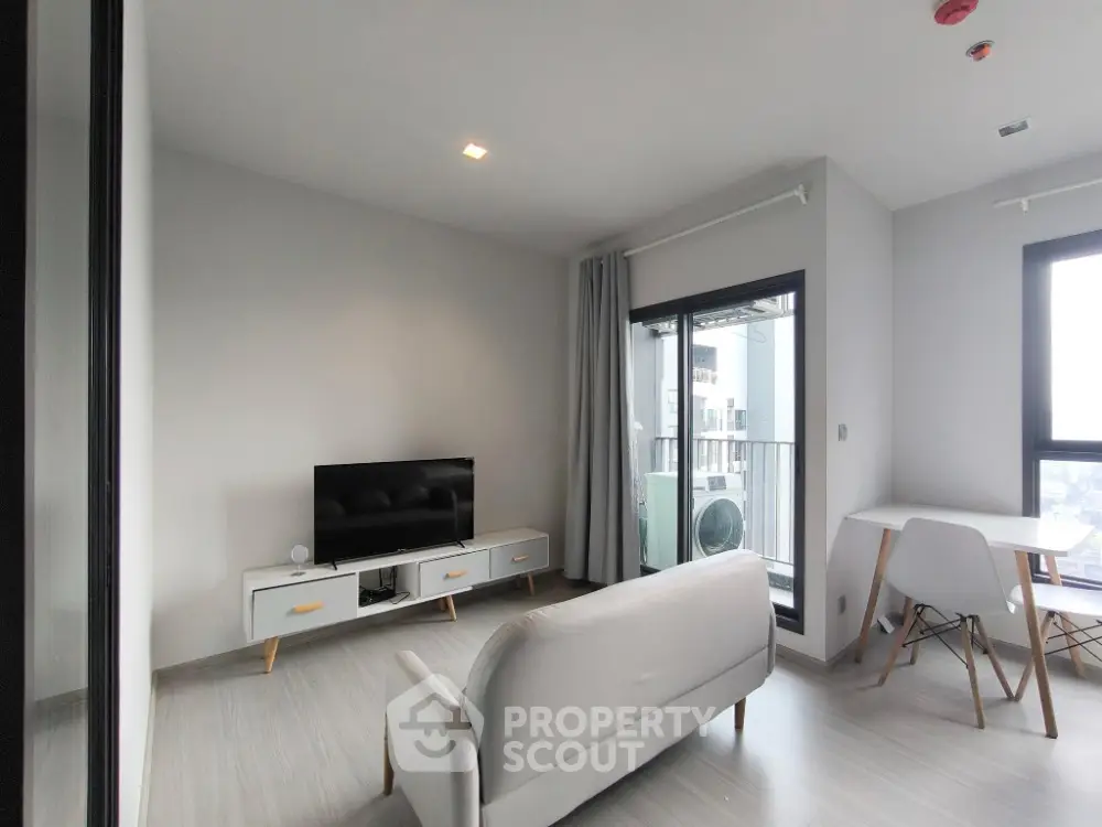 Modern living room with sleek furniture and balcony view in contemporary apartment.