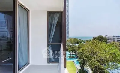 Stunning balcony view with lush greenery and ocean backdrop in modern apartment