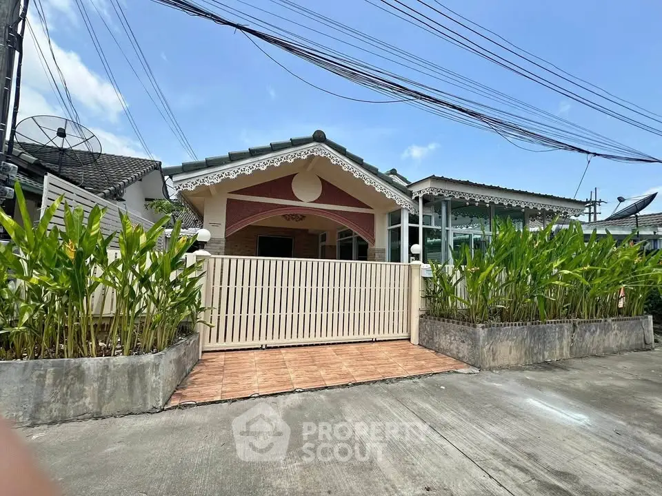 Charming single-story house with decorative facade and lush greenery in a serene neighborhood.