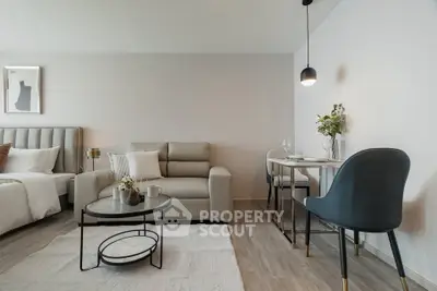 Modern studio apartment with stylish living area and dining space, featuring elegant decor and cozy ambiance.