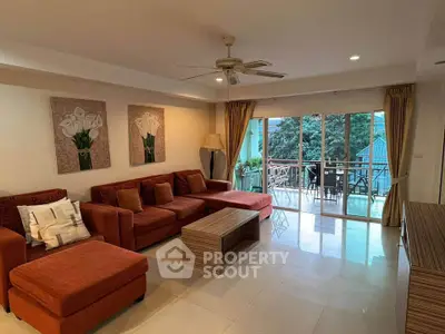 Spacious living room with large windows and balcony access, featuring modern furniture and elegant decor.