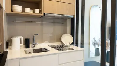 Modern kitchen with sleek design, induction cooktop, and stylish cabinetry in a contemporary apartment.