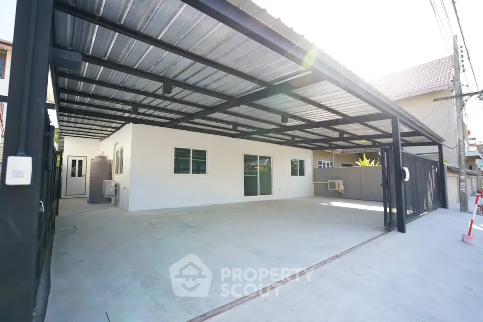 Spacious covered parking area with modern metal roof and concrete flooring