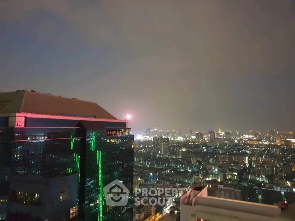 Stunning cityscape view from high-rise building at night with vibrant city lights.