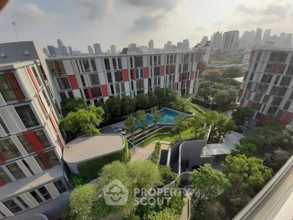 Modern apartment complex with lush garden and pool view in urban setting