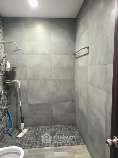Modern bathroom with sleek gray tiles and walk-in shower design.