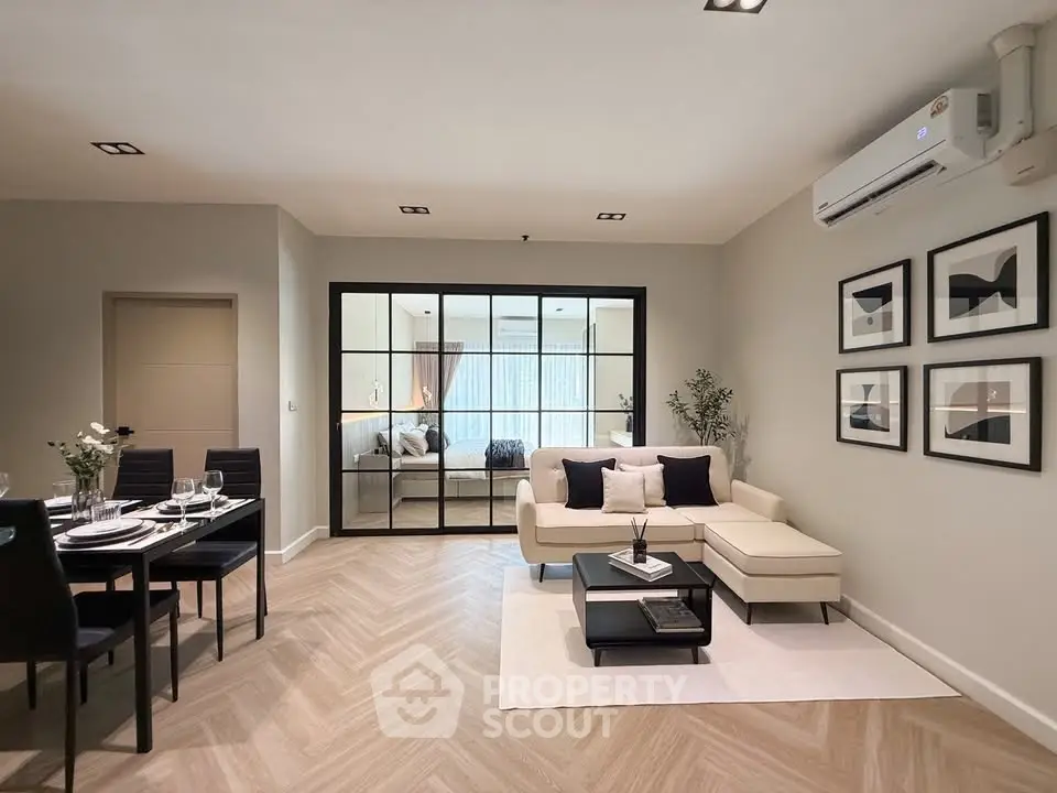 Modern living room with elegant decor and open layout, featuring a cozy dining area and stylish furniture.