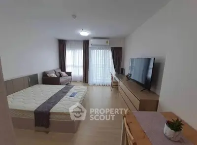 Spacious bedroom with modern furnishings and large window offering natural light.