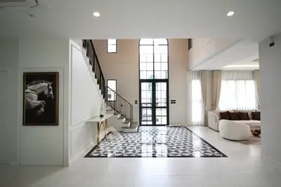 Elegant modern living room with high ceilings and stylish staircase