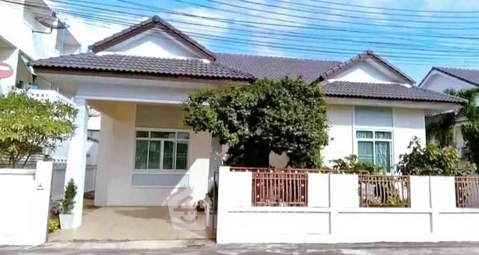Charming single-story house with tiled roof and lush greenery in a serene neighborhood.