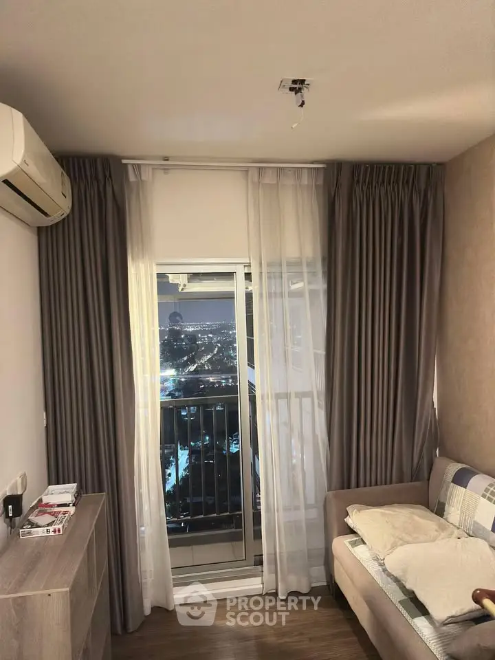 Cozy bedroom with balcony view, featuring air conditioning and elegant curtains for a comfortable living experience.