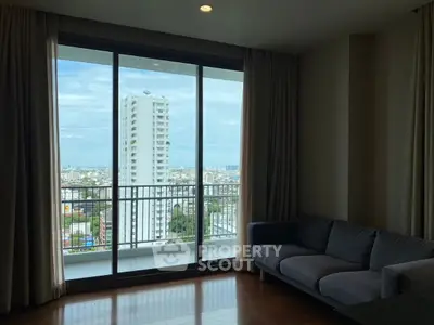 Spacious living room with stunning city view from large balcony window.