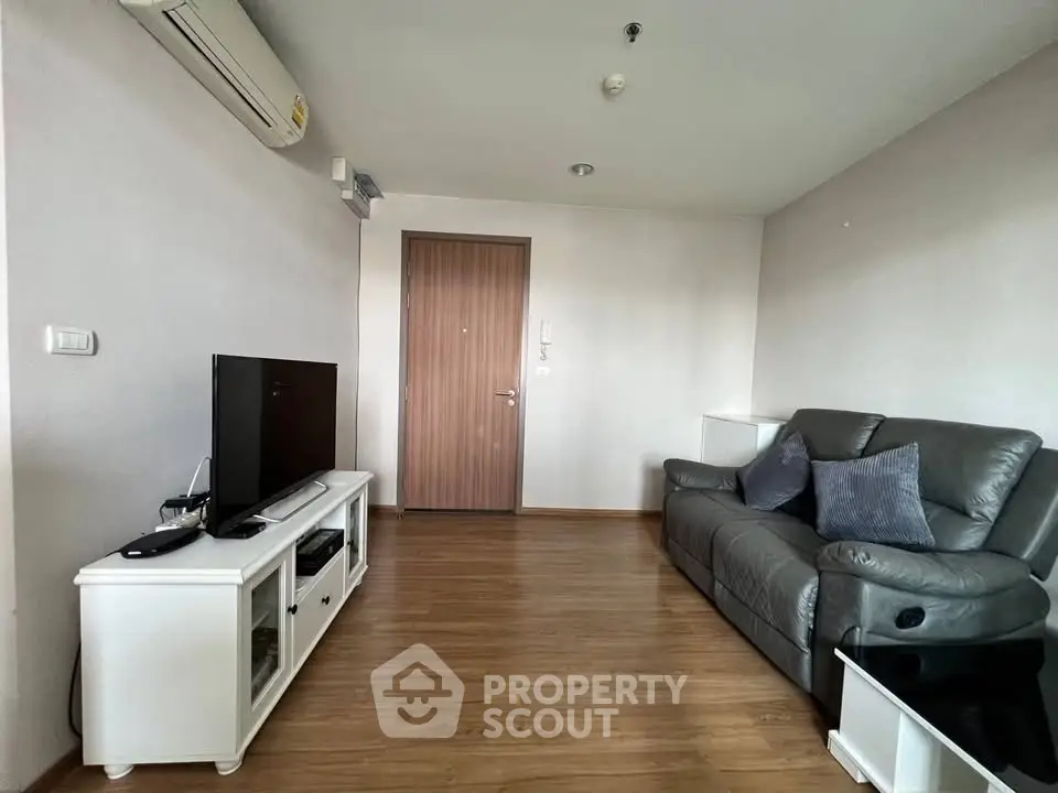 Modern living room with sleek furniture and wooden flooring in a cozy apartment.