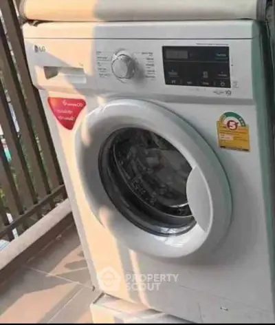 Modern washing machine on a balcony with sunlight, perfect for urban living convenience.