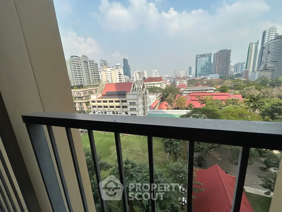 Stunning cityscape view from a high-rise balcony overlooking urban skyline and greenery.