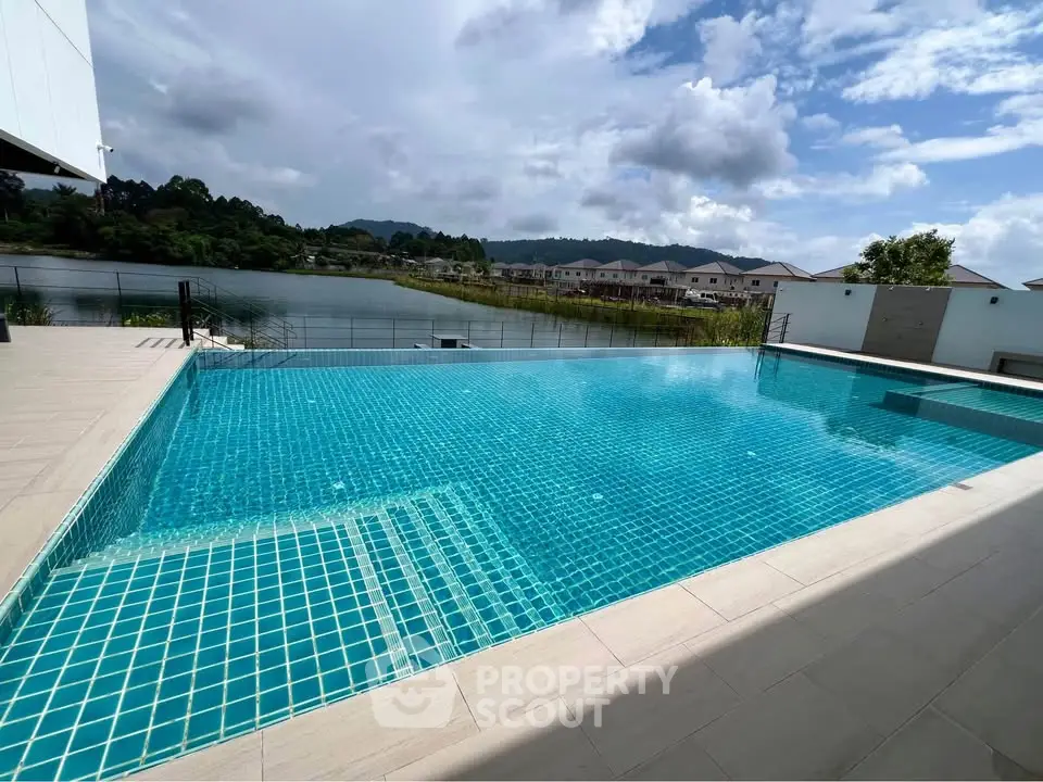 Stunning infinity pool with serene lake view in luxury residential area.
