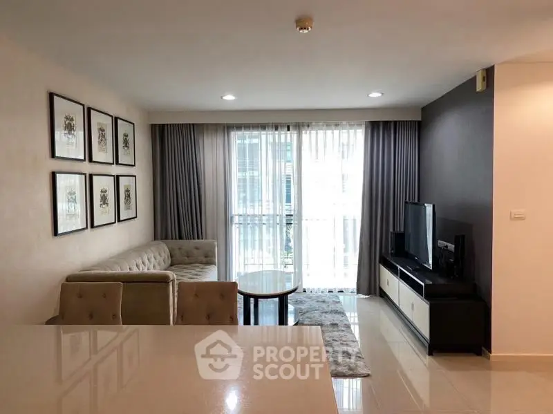Modern living room with stylish decor and natural light, featuring a cozy sofa and entertainment center.
