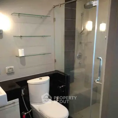 Modern bathroom with glass shower and sleek fixtures in a contemporary apartment.