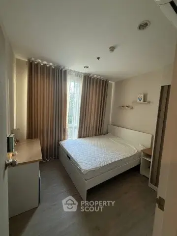 Cozy bedroom with natural light and modern furnishings in a stylish apartment.