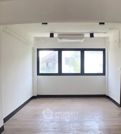 Spacious unfurnished room with large window and air conditioning