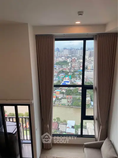 Stunning high-rise apartment with panoramic city and river views from a large window.