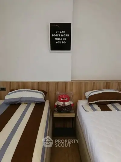 Cozy bedroom with twin beds and motivational wall art, perfect for relaxation and inspiration.