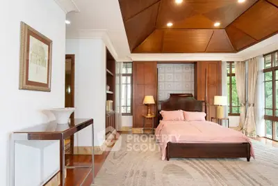 Luxurious bedroom with elegant wooden ceiling and large windows offering natural light.