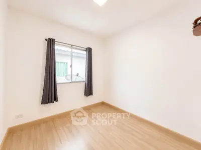 Spacious unfurnished bedroom with wooden flooring and natural light