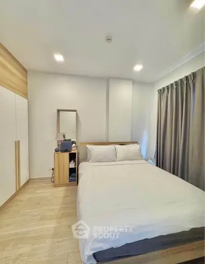 Cozy bedroom with modern decor, featuring a comfortable bed, wooden wardrobe, and soft lighting.