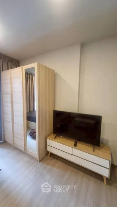 Modern bedroom with sleek wardrobe and stylish TV stand