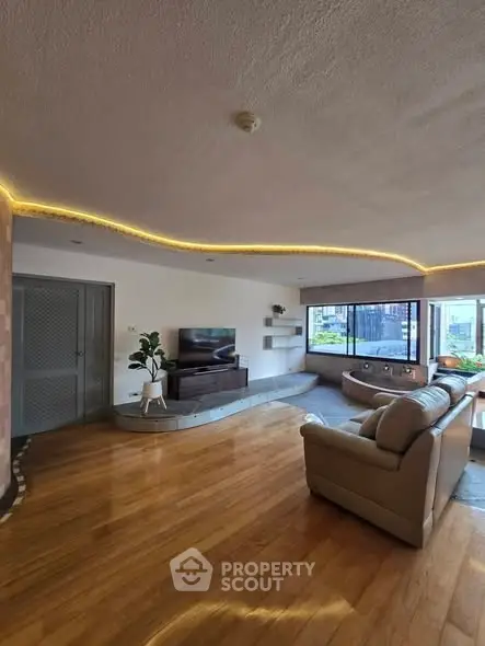 Spacious living room with modern decor and large windows offering natural light.