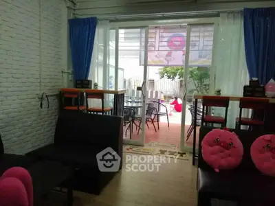 Charming living room with sliding glass doors leading to a cozy outdoor patio area.