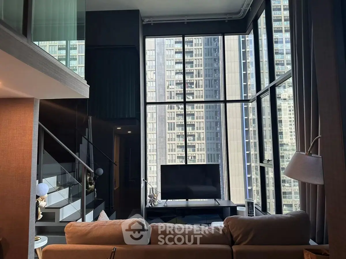 Luxurious modern living room with floor-to-ceiling windows and stunning city view.