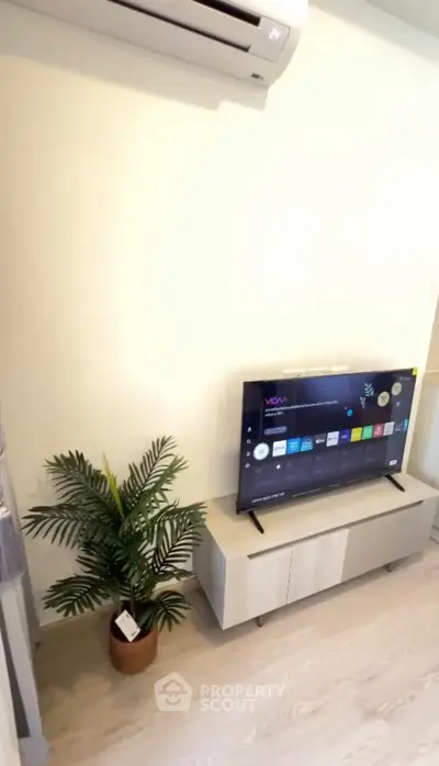 Modern living room with sleek TV setup and air conditioning, perfect for cozy entertainment.