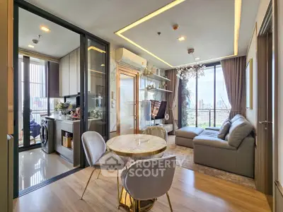 Modern living room with open kitchen and city view, featuring elegant decor and cozy seating area.