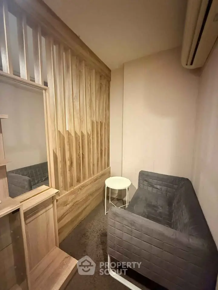 Cozy small living room with modern gray sofa and wooden accents, perfect for compact spaces.